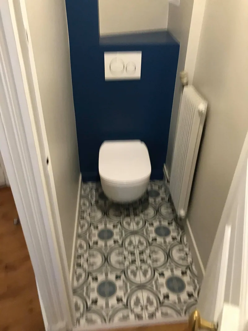 WC suspendu, mur bleu nuit et carreaux de ciment — appartement de 65 m², Paris 17e